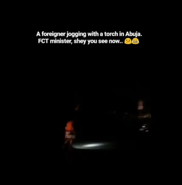 "No Light"; White Man Spotted Jogging With His Torchlight In Abuja Photos